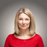 Portraitfoto von Kathrin Anders vor grauem Hintergrund.