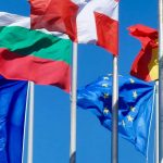 Symbolbild Europa - Europafahne und Fahnen der Mitgliedsstaaten im Wind vor blauem Himmel