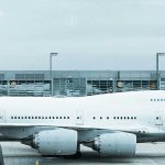 Flughafen Symbolbild - Wartehalle mit Lufthansa Flugzeug auf Rollbahn im Hintergrund